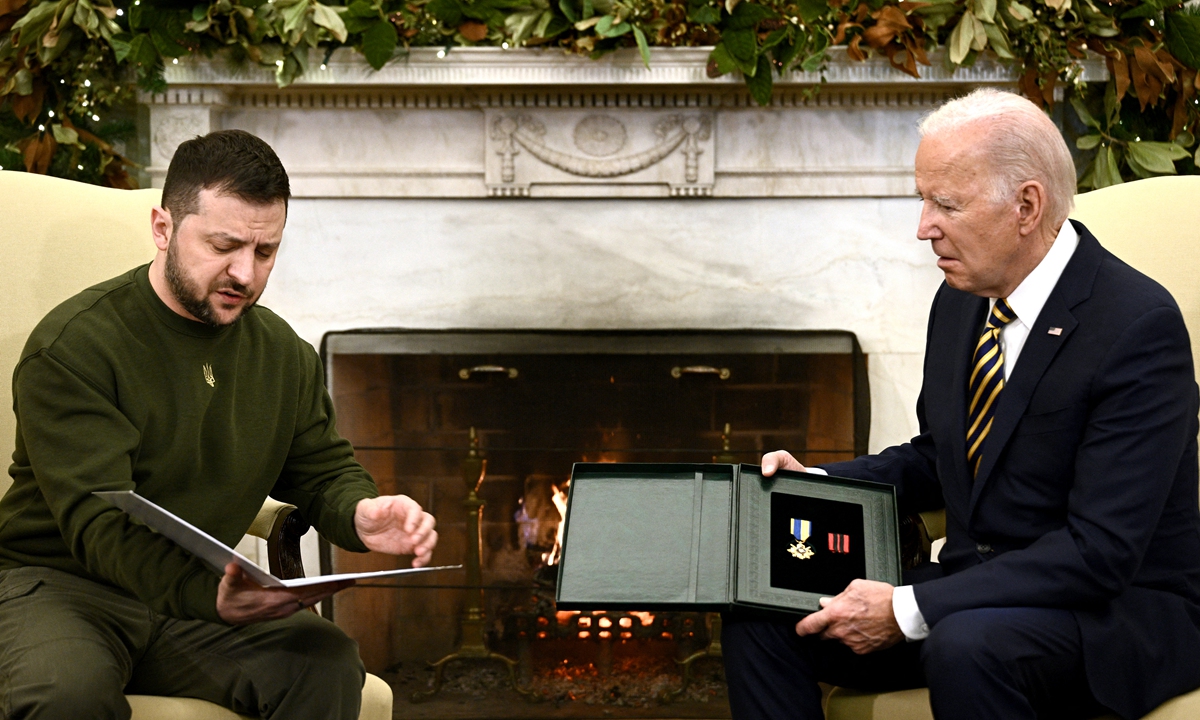 Ukraine's President Volodymyr Zelensky presents a Ukrainian military medal to US President Joe Biden in the Oval Office of the White House, in Washington, DC on December 21, 2022. Photo: AFP