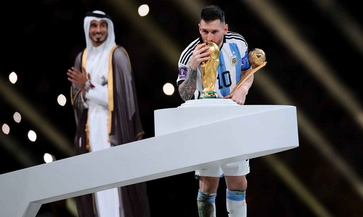 Lionel Messi of Argentina kisses the World Cup Trophy while holding the Golden Boot award on December 18, 2022 in Lusail City, Qatar. Photo: VCG