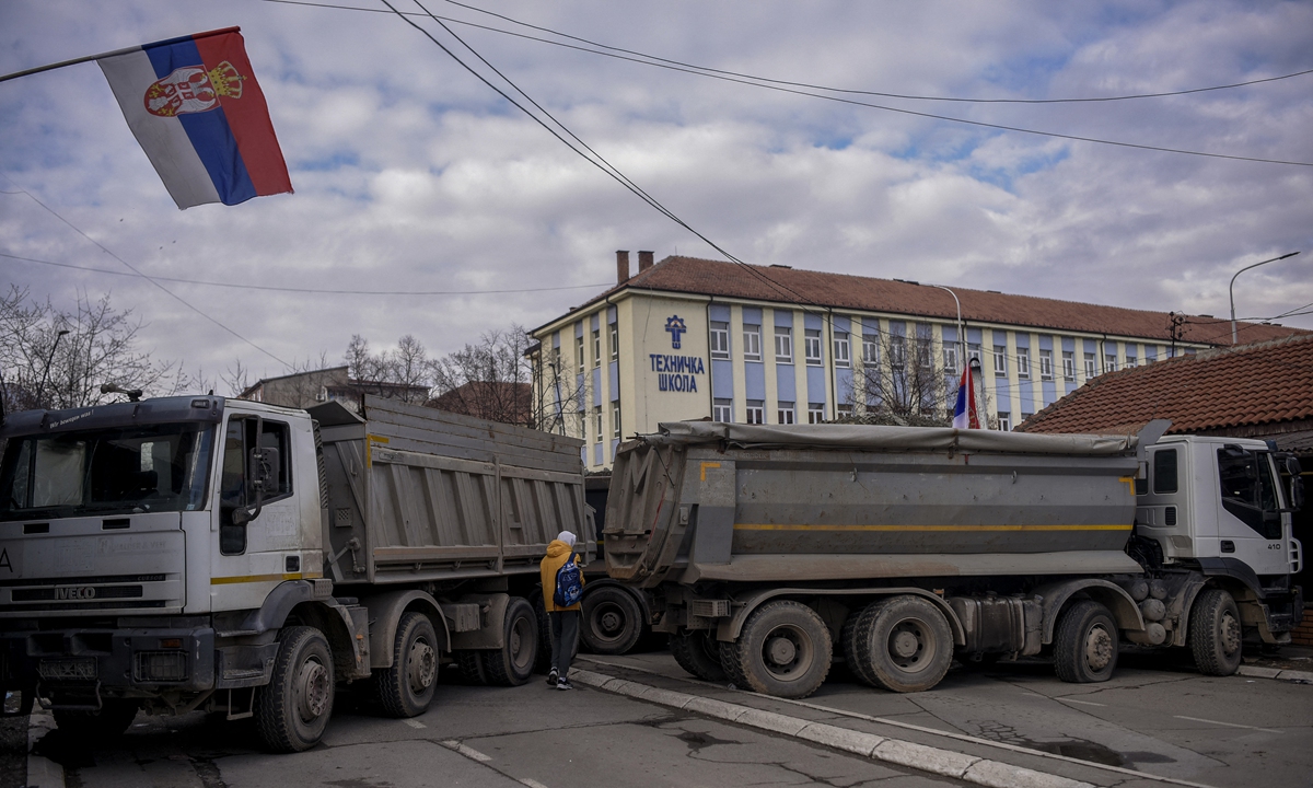 A pedestrian walks past a new road barricade set up in Mitrovica of Kosovo on December 28, 2022. Serbian armed forces are on highest level of alert, media reported. Photo: AFP