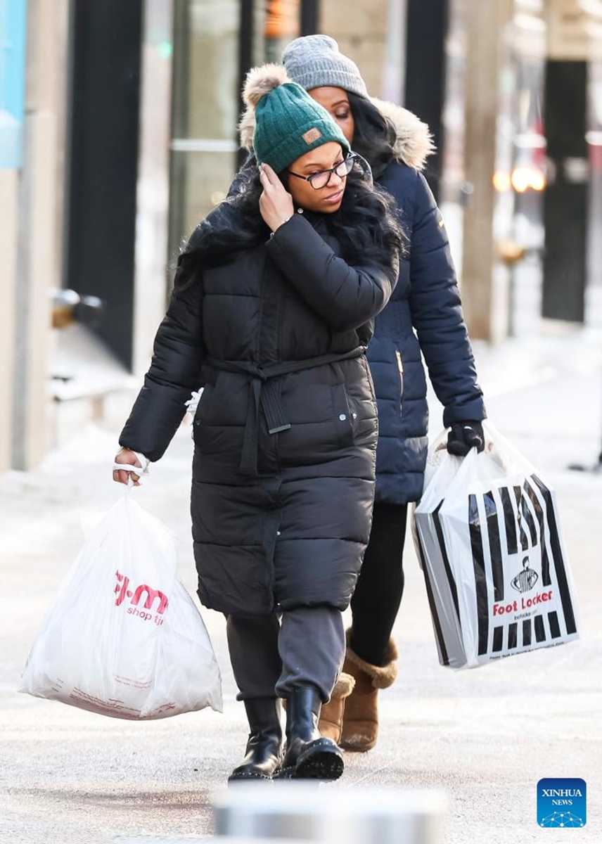 People do some last minute Christmas shopping in downtown Chicago, the United States, on Dec. 24, 2022. A strong winter storm swept through Chicago. (Photo by Joel Lerner/Xinhua)