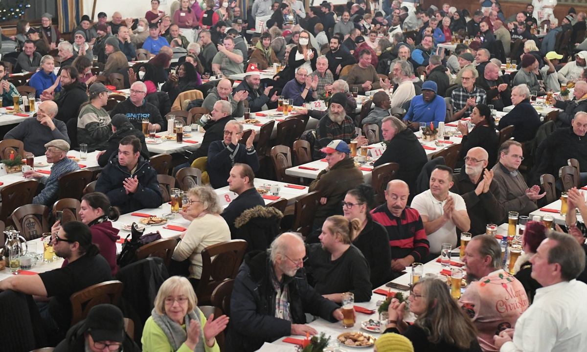 Homeless people wait for food in the ballroom of the Munich Hofbr'uhaus at the Homeless Christmas 2022 of the Catholic Men's Welfare Association Munich in Bavaria, Germany on December 24, 2022. Photo: VCG