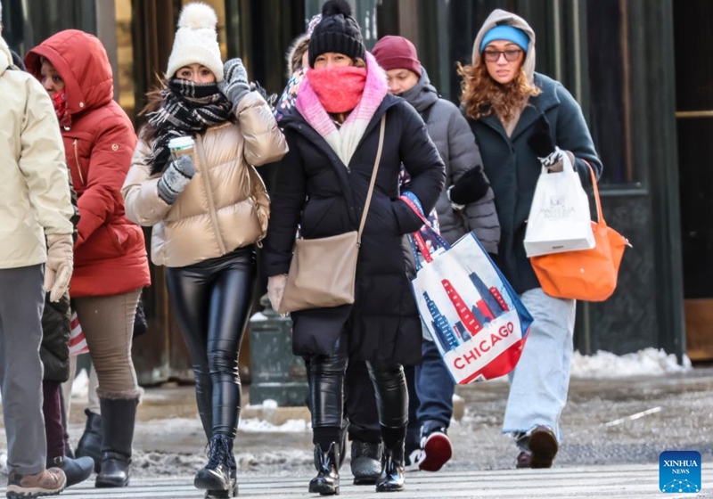 People do some last minute Christmas shopping in downtown Chicago, the United States, on Dec. 24, 2022. A strong winter storm swept through Chicago. (Photo by Joel Lerner/Xinhua)