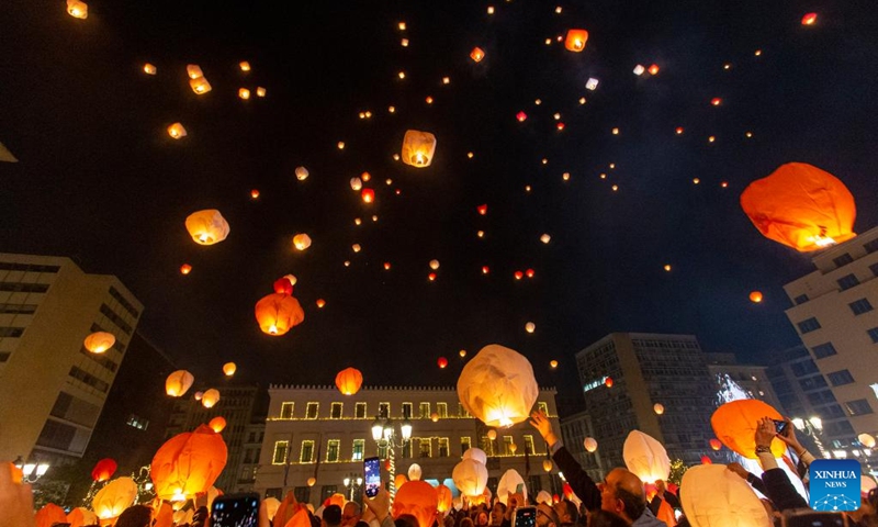 The sky of Athens is lit up by dozens of traditional paper lanterns in Athens, Greece, on Dec. 24, 2022. The Municipality of Athens invited the Athenians on Christmas Eve at Kotzia square, to the Night of the Wishes where everybody could release their wishes to the sky inside the traditional paper lanterns. (Xinhua/Marios Lolos)