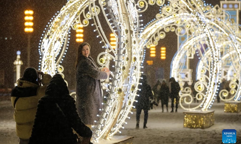 A woman poses for pictures with decorations for the New Year in Moscow, Russia, on Dec. 27, 2022.(Photo: Xinhua)