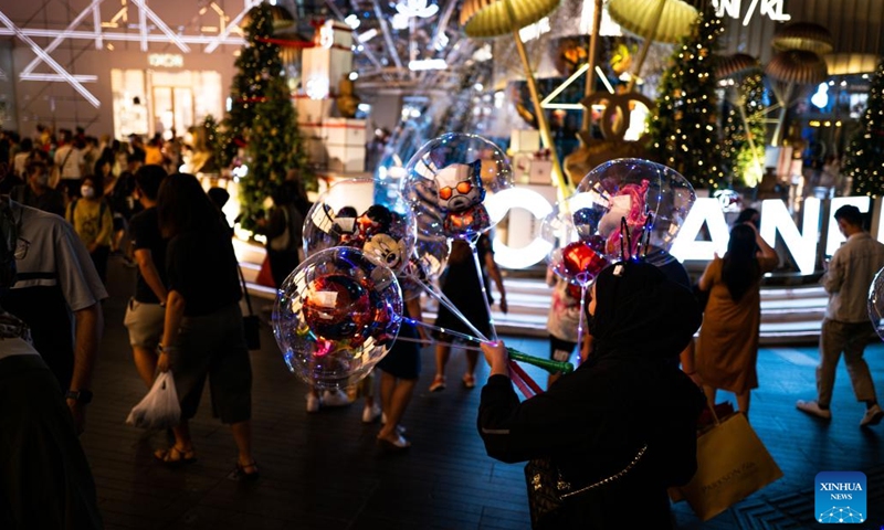 A woman sells balloons outside a shopping mall in Kuala Lumpur, Malaysia, Dec. 26, 2022.(Photo: Xinhua)