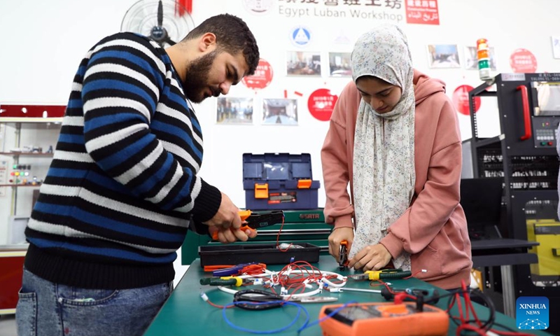 Trainees learn circuit connection at the computer numerical control (CNC) installation training area of Luban Workshop at Ain Shams University in Cairo, Egypt, on Dec. 21, 2022. At a workshop in Ain Shams University in Cairo, a number of engineering students were being trained on how to use G-code, a programming language, to create an automated control of a machine.(Photo: Xinhua)
