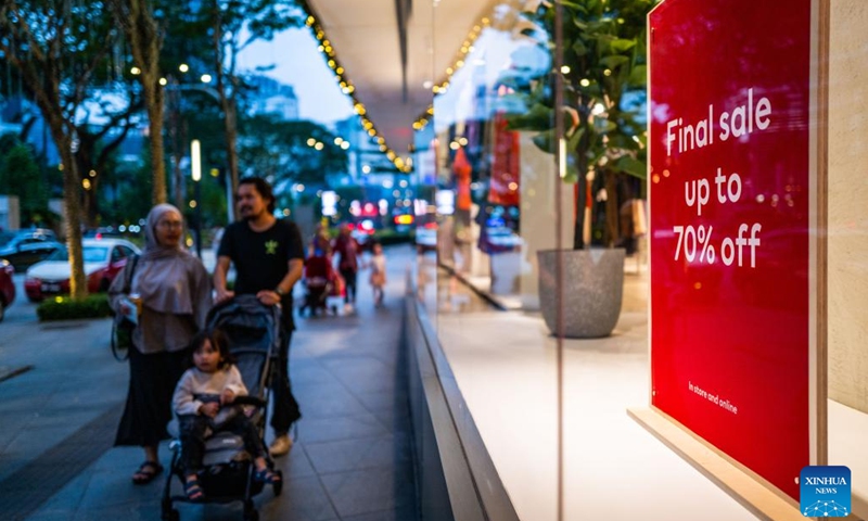 People walk past a final sale signboard in Kuala Lumpur, Malaysia, Dec. 26, 2022.(Photo: Xinhua)