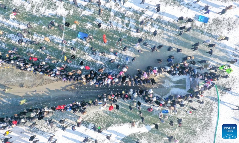 This aerial photo taken on Dec. 28, 2022 shows people watching winter fishing on the Chagan Lake in Songyuan City, northeast China's Jilin Province. A winter fishing-themed festival opened on Wednesday at Chagan Lake, marking the beginning of the annual golden season for winter fishing here.(Photo: Xinhua)