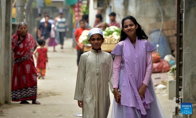 This photo taken on Nov. 28, 2022 shows Alifa Chin (China in Bengali), who was born on China's naval hospital ship Peace Ark in 2010, and her brother walking down an alley in Dhaka, Bangladesh.(Photo: Xinhua)