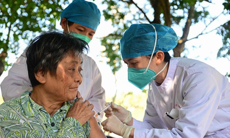 A medical worker administers a dose of COVID-19 vaccine to a senior resident in Hufeng Village of Wenchang, south China's Hainan Province, Dec. 22, 2022.The door-to-door services have been offered to help the elderly get COVID-19 vaccinations in the city of Wenchang. (Xinhua)