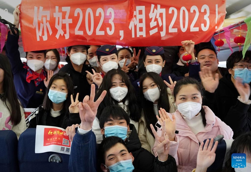 Attendants of train G2023 pose for a photo with passengers on the train running from Shangqiu in central China's Henan Province to Lanzhou in northwest China's Gansu Province, Jan. 1, 2023. Various activities to celebrate the new year were held on the train G2023 as the number of the train coincides with the year of 2023. (Xinhua/Li An)