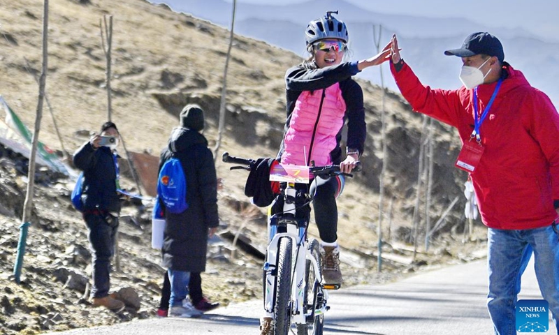 A participant celebrates after reaching the finish line during a bicycle competition in Lhasa, capital of southwest China's Tibet Autonomous Region, Jan. 1, 2023. People take part in various leisure activities to spend the New Year holiday. (Xinhua/Zhang Rufeng)