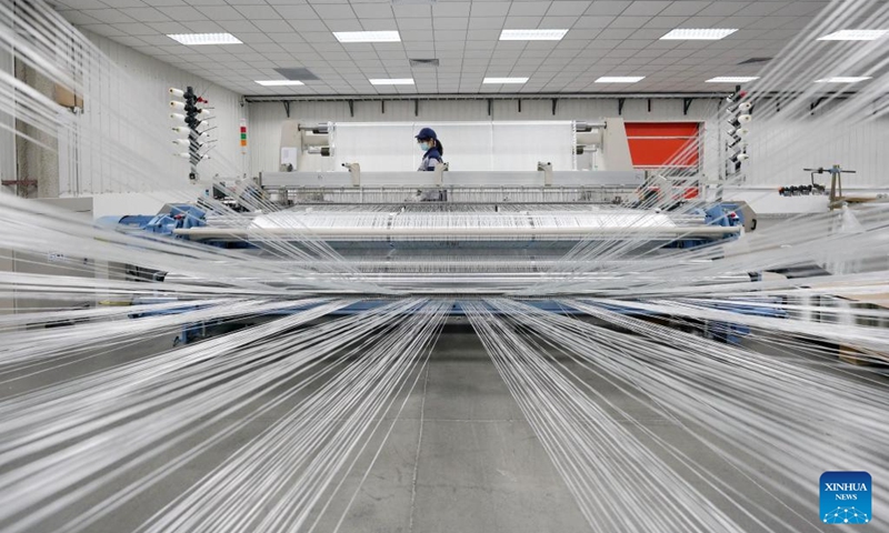 An employee works at a fiberglass workshop of a glass products company in Shahe City, north China's Hebei Province, Jan. 6, 2023. Glass products companies in Shahe have stepped up production to guarantee the completion of orders from domestic and foreign customers at the beginning of the new year. (Xinhua/Mu Yu)