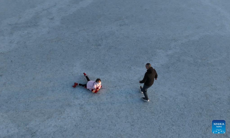 This aerial photo taken on Jan. 2, 2023 shows people having fun on the ice in Tangshan Haigang Economic Development Zone of Tangshan, north China's Hebei Province. (Photo by Liu Mancang/Xinhua)