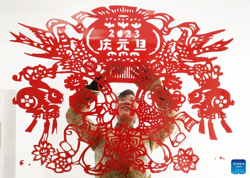 A woman makes paper cutting works in Fengrun District of Tangshan, north China's Hebei Province, Jan. 1, 2023. (Photo by Zhu Dayong/Xinhua)