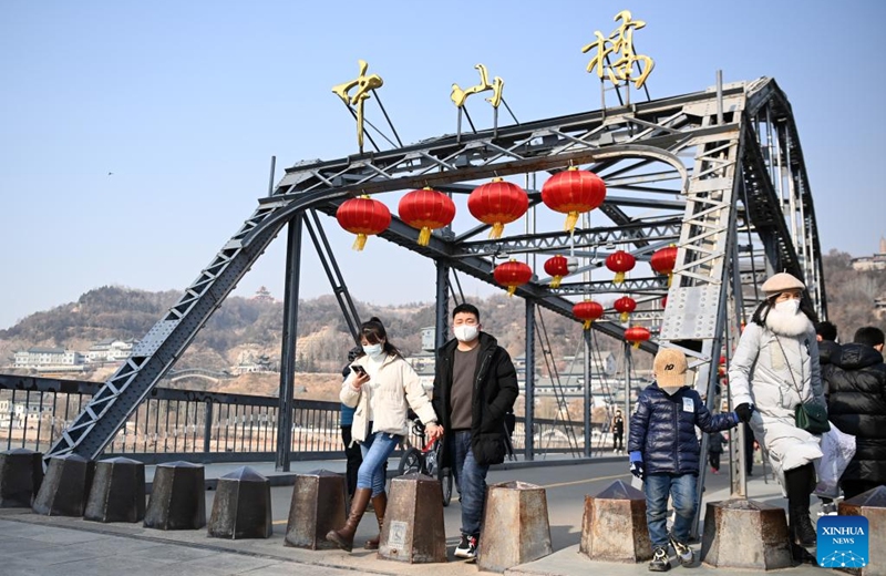 People visit Zhongshan bridge in Lanzhou, northwest China's Gansu Province, Jan. 1, 2023. People take part in various leisure activities to spend the New Year holiday. (Xinhua/Fan Peishen)