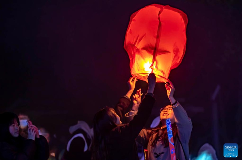 People release a sky lantern to make a wish for good fortune at a park in Qianxi, southwest China's Guizhou Province, Jan. 1, 2023. (Photo by Fan Hui/Xinhua)
