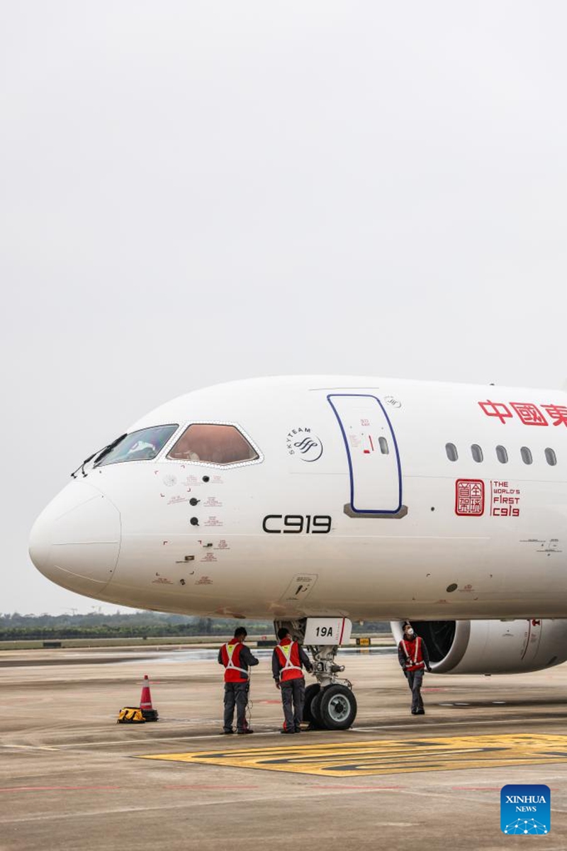 Technicians check a C919 large passenger aircraft, China's first homegrown large jetliner, at Meilan International Airport in Haikou, south China's Hainan Province, Jan. 2, 2023. The aircraft, which belongs to China Eastern Airlines, landed at Meilan International Airport in Haikou on Monday as a part of the 100-hour aircraft validation flight process. The testing process will comprehensively verify the reliability of the C919 with commercial operation in mind -- with the aim of ensuring its safety and efficiency. (Xinhua/Zhang Liyun)