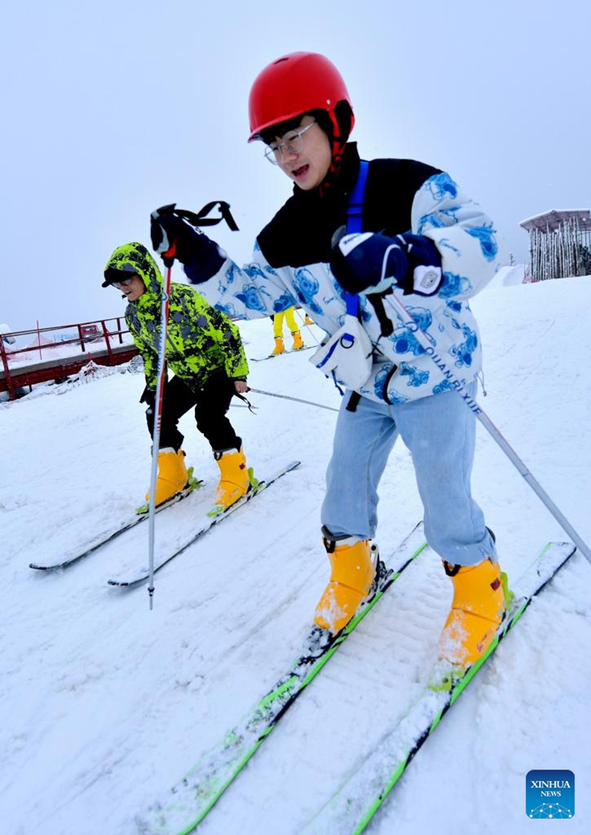 People enjoy skiing at a ski resort in Xuanen County, central China's Hubei Province, Jan. 2, 2023. (Photo by Chen Xukai/Xinhua)