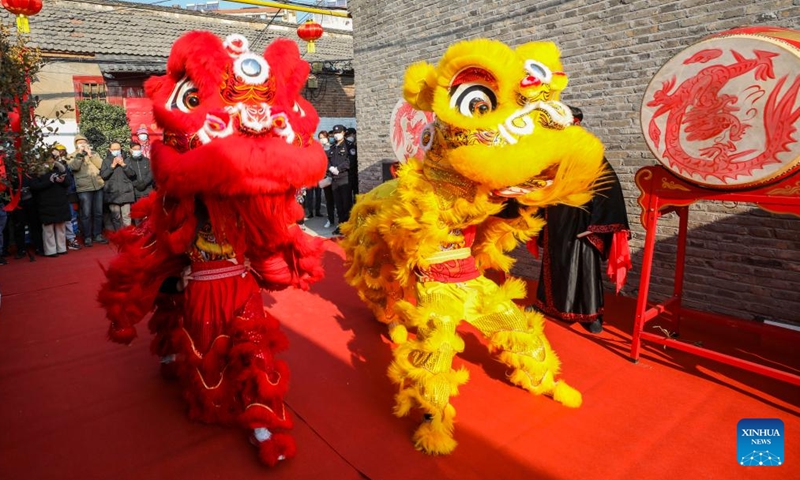 People watch lion dance at a scenic spot in Huai'an, east China's Jiangsu Province, Dec. 31, 2022. (Photo by Zhao Qirui/Xinhua)