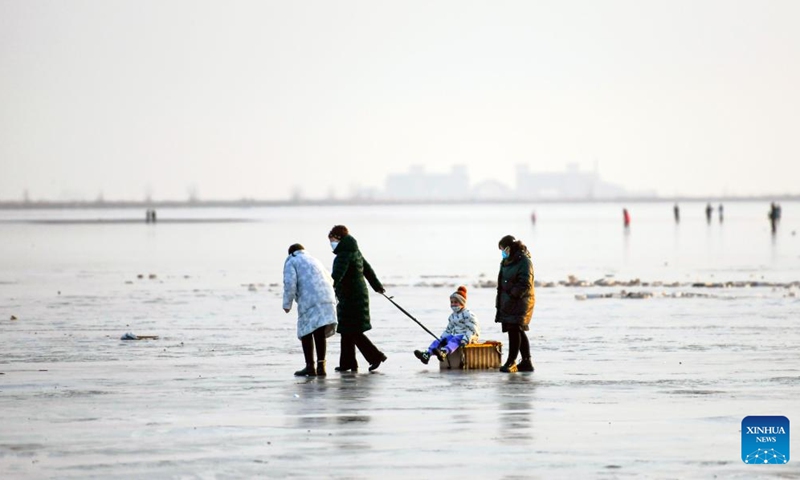 People have fun on the ice in Tangshan Haigang Economic Development Zone of Tangshan, north China's Hebei Province, Jan. 2, 2023. (Photo by Liu Mancang/Xinhua)