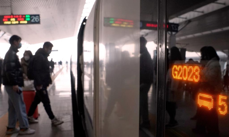 Passengers board train G2023 at Zhengzhou East Railway Station in Zhengzhou, central China's Henan Province, Jan. 1, 2023. Various activities to celebrate the new year were held on the train G2023 as the number of the train coincides with the year of 2023. (Xinhua/Li An)