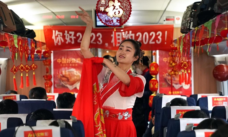 A crew member stages a performance on the train G2023 running from Shangqiu in central China's Henan Province to Lanzhou in northwest China's Gansu Province, Jan. 1, 2023. Various activities to celebrate the new year were held on the train G2023 as the number of the train coincides with the year of 2023. (Xinhua/Li An)
