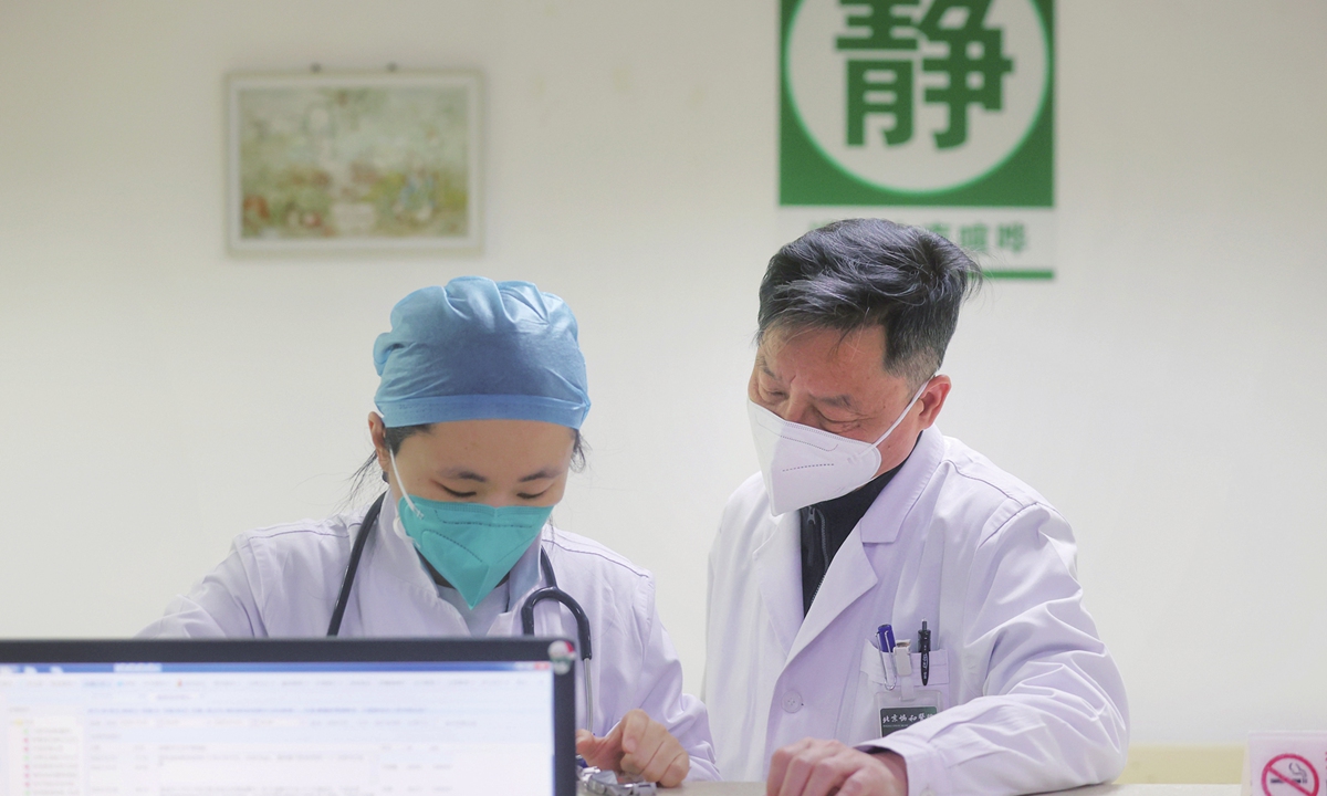 Li Taisheng (right), director of infectious diseases department at the Peking Union Medical College Hospital, talks with a colleague about the conditions of patients on December 31, 2022.