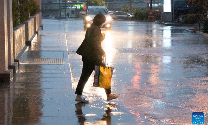 A pedestrian walks in storm in Millbrae, California, the United States, Jan. 4, 2023. A winter storm hit northern California, bringing rain and snow to the local area.(Photo: Xinhua)