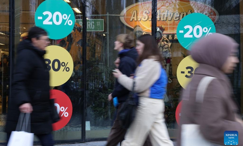 People walk past advertisements of winter sales in Brussels, Belgium, on Jan. 3, 2023. Belgium's 2023 winter sales take place from Jan. 3 to Jan. 31.(Photo: Xinhua)