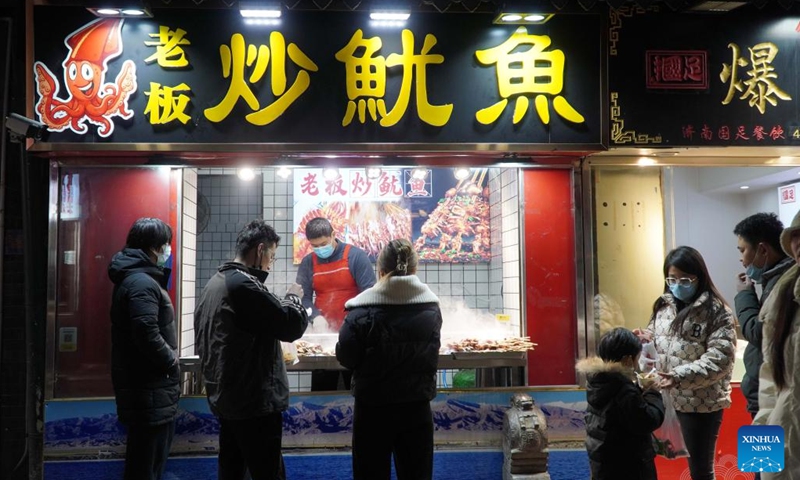 People buy food on Furong Street in Jinan, east China's Shandong Province, Jan. 2, 2023. Furong Street, a 500-meter-long old street with more than 150 food and beverage shops, is getting back to its hustle and bustle these days.(Photo: Xinhua)
