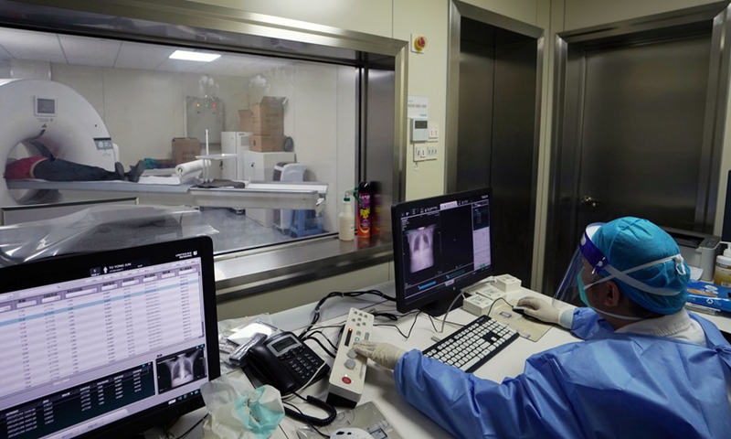 A medical worker conducts a computed tomography (CT) scan for a patient at the fever clinic of a community healthcare institution in Jiuting Town of Songjiang District, east China's Shanghai, Jan. 4, 2023.(Photo: Xinhua)