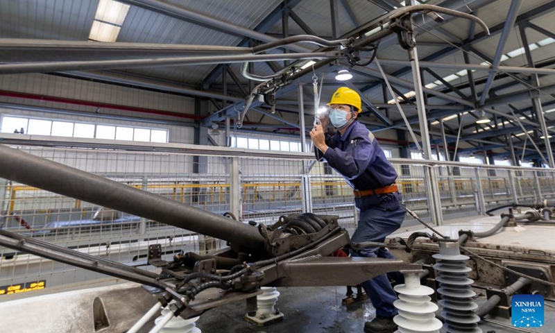 A worker carries out maintenance at the Hongqiao high-speed train depot in east China's Shanghai, Jan. 3, 2023. Railway workers of the Hongqiao high-speed train depot have stepped up their efforts on maintenance work for trains to prepare for the future travel rush during the Chinese Lunar New Year.(Photo: Xinhua)