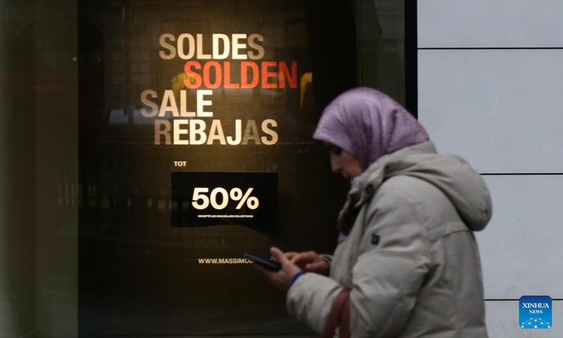 A woman walks past an advertisement of winter sales on a street in Brussels, Belgium, on Jan. 3, 2023. Belgium's 2023 winter sales take place from Jan. 3 to Jan. 31.(Photo: Xinhua)