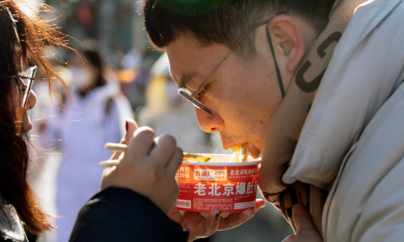 People enjoy food at the Nanluoguxiang Lane in Beijing, capital of China, Jan. 27, 2023. People enjoy the last day of the Spring Festival holiday on Friday. Photo: Xinhua