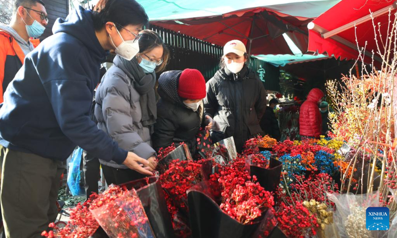 People buy flowers ahead of the Spring Festival at a market in Xuhui District of east China's Shanghai Jan. 18, 2023. This year's Spring Festival, the Chinese traditional lunar New Year, starts from Jan. 22. (Xinhua/Fang Zhe)