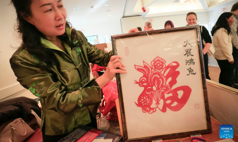 A vendor displays a paper-cut artwork themed on the Year of the Rabbit at the Lunar New Year Market hosted by University of British Columbia (UBC) Botanical Garden in Vancouver, British Columbia, Canada, on Jan. 14, 2023. (Photo by Liang Sen/Xinhua)