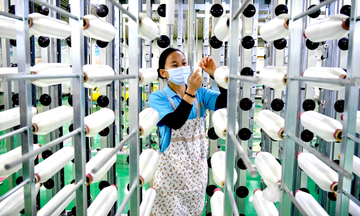 A staffer makes products in the workshop of a chemical fiber company on January 30, 2023 in Bozhou, East China's Anhui Province. Local enterprises are going all out to step up orders and production as they strive to achieve a good start for the first quarter.Photo:cnsphoto