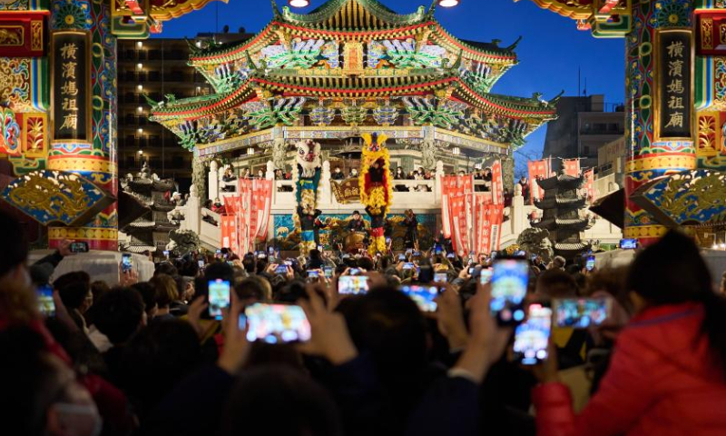 Tourists watch lion dance performance in the Chinatown of Yokohama, Japan, Feb. 5, 2023. Photo: Xinhua