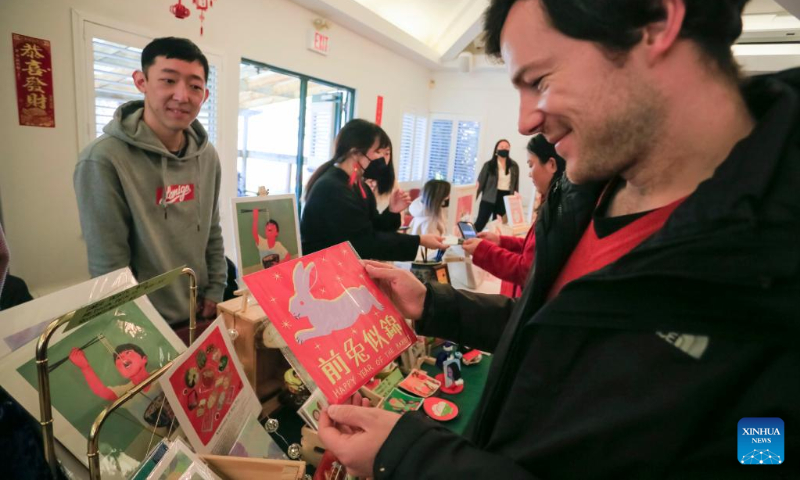 A customer shops for goods themed on the Year of the Rabbit at the Lunar New Year Market hosted by University of British Columbia (UBC) Botanical Garden in Vancouver, British Columbia, Canada, on Jan. 14, 2023. (Photo by Liang Sen/Xinhua)