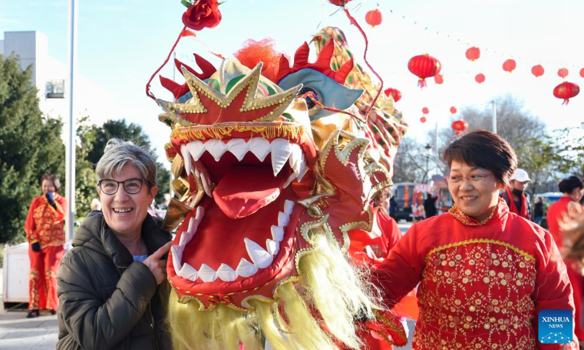 A resident poses for a photo with a lion dancer during an event to celebrate the Chinese New Year in Madrid, Spain, Jan 20, 2023. Photo:Xinhua