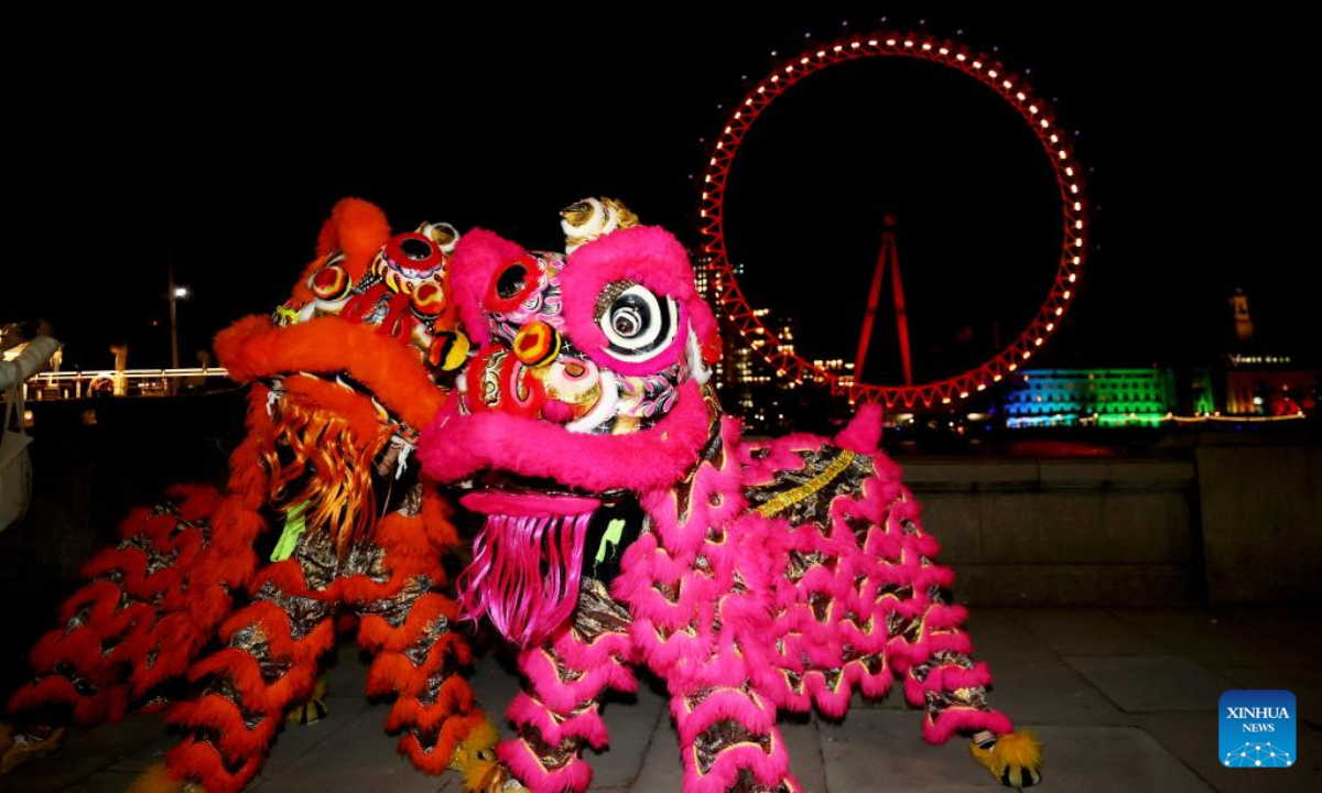 Traditional Chinese lion dancers perform in front of the London Eye which is lit up in red to celebrate the upcoming Chinese New Year in London, Britain, Jan 13, 2023. Photo:Xinhua