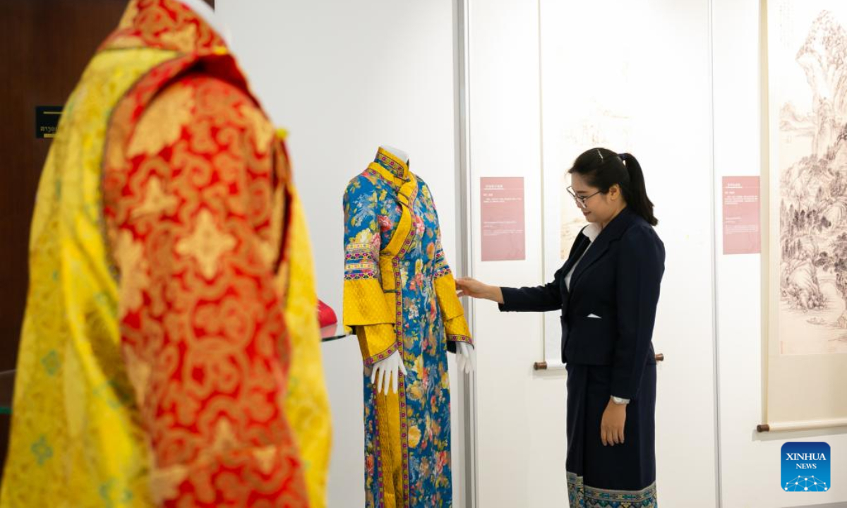 A visitor watches traditional clothes at the Ancient Chinese Landscape Painting Exhibition themed