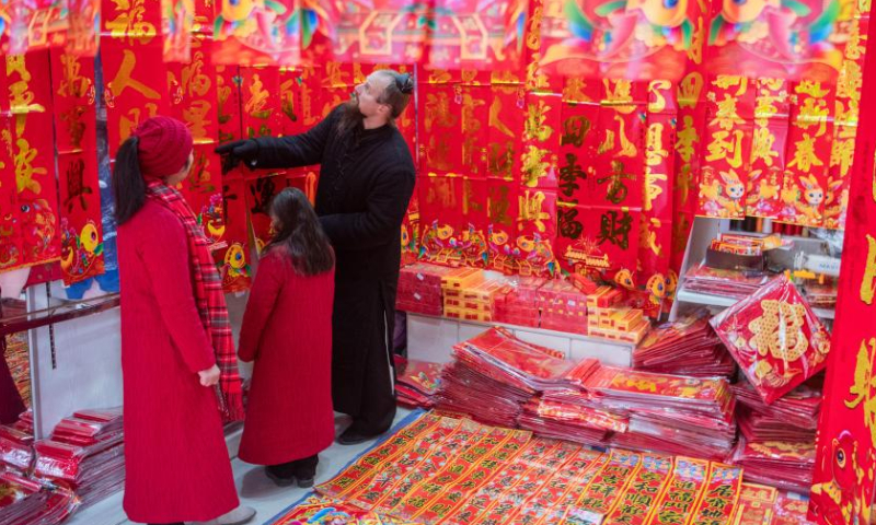Jake Lee Pinnick and his family select Spring Festival couplets in Danjiangkou, central China's Hubei Province, Jan. 12, 2023. Photo: Xinhua