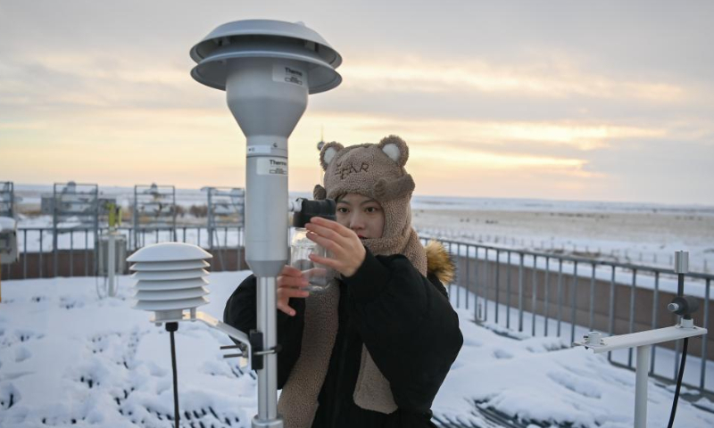 Dong Yinxi, an observer at the Akdala atmospheric background station, checks a monitor equipment at the rooftop in the Junggar Basin, northwest China's Xinjiang Uygur Autonomous Region, Jan. 8, 2023. Photo: Xinhua