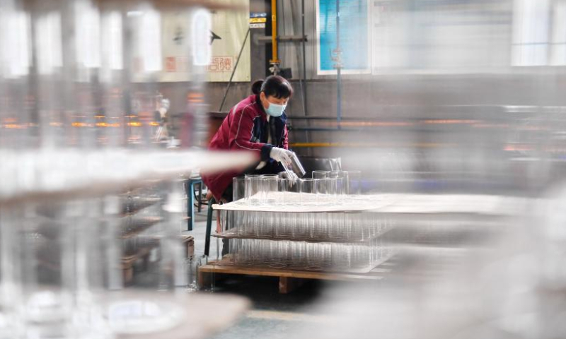 A worker arranges glasswork at the workshop of a company in Hejian City, north China's Hebei Province, Feb. 11, 2023. Hejian City is famous for its glasswork making industry. Now, there are more than 200 glasswork making companies and over 60,000 staff members involved in the industry in Hejian. The annual output of the glasswork reached nearly 10 billion yuan (about 1.47 billion U.S. dollars) and the glasswork has been exported to over 50 countries and regions. Photo: Xinhua
