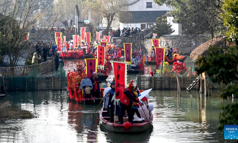 People take part in a parade welcoming the God of Wealth along waterways at Digang Village in Huzhou, east China's Zhejiang Province, Jan. 26, 2023. Ceremonies were held to welcome the God of Wealth as a tradition on the fifth day of the Chinese Lunar New Year, which falls on Thursday this year. Photo: Xinhua