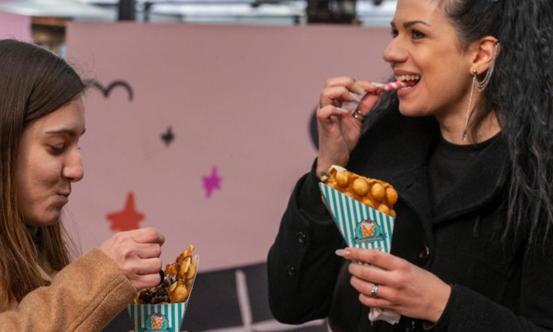 Visitors enjoy chocolate waffles at the 4th Chocolate Fest in Athens, Greece, Feb. 11, 2023. Photo: Xinhua