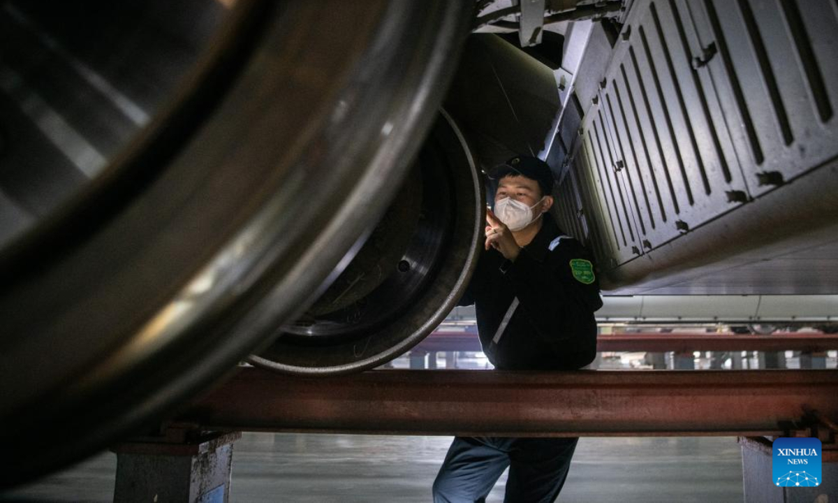 A worker examines a train at a maintenance base in Wuhan, central China's Hubei Province, Jan 6, 2023. Photo:Xinhua