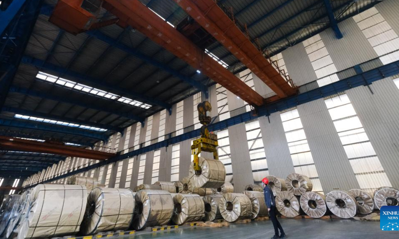 A staff member lifts finished steel coil at a special steel company in Xinfeng Town of Nanhu District, Jiaxing, east China's Zhejiang Province, Jan. 26, 2023. Many companies in Nanhu District of Jiaxing have sped up production during the Spring Festival holiday to ensure delivery of orders, while offering cash gifts and other rewards for employees. Photo: Xinhua